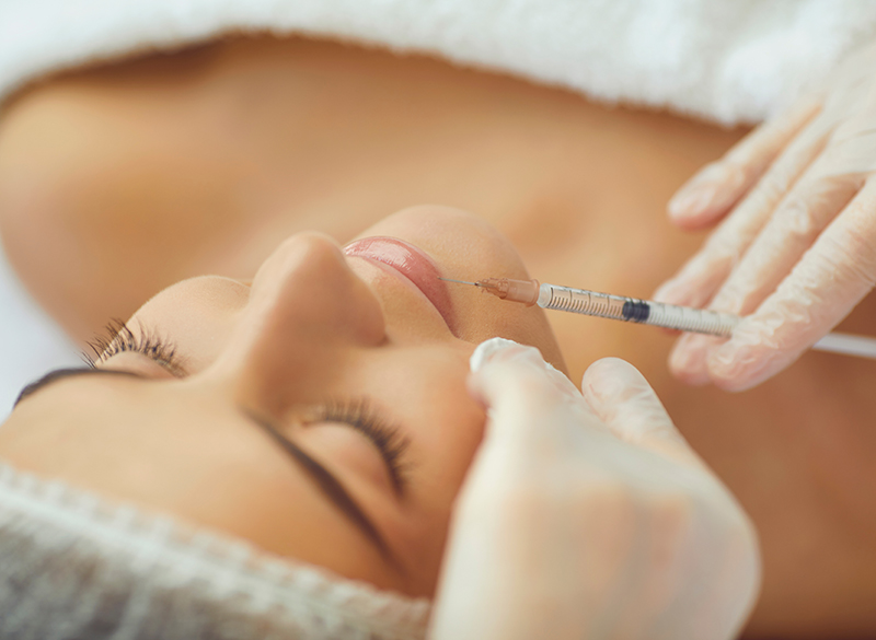 Cosmetologist making botox filler injection